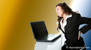 a person Tonawanda bending over a computer holding her back due to pain